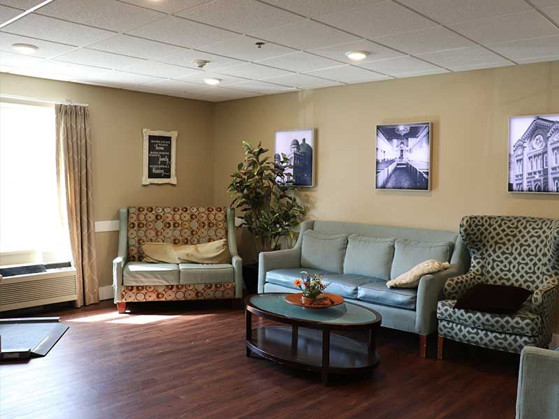 A cozy living room with sofas, a coffee table, and decorative artwork.