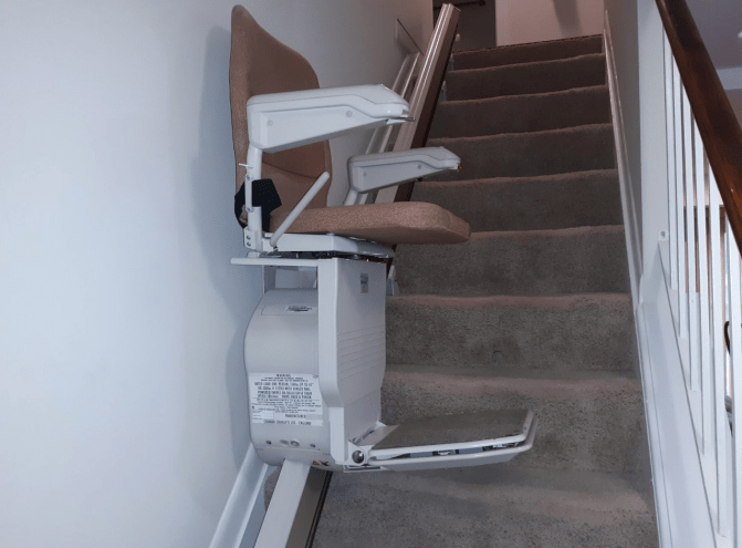 A stairlift installed on a carpeted staircase for improved accessibility.