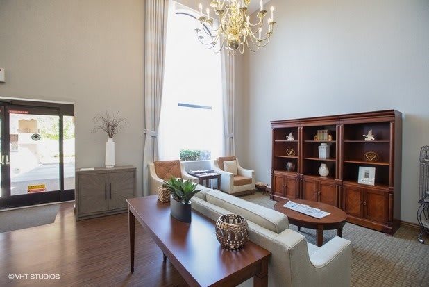 A well-furnished living room with a chandelier, sofa, and bookshelf.