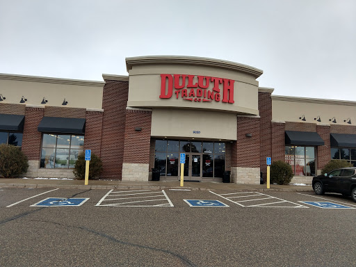 A retail store entrance viewed from the parking lot on a cloudy day.