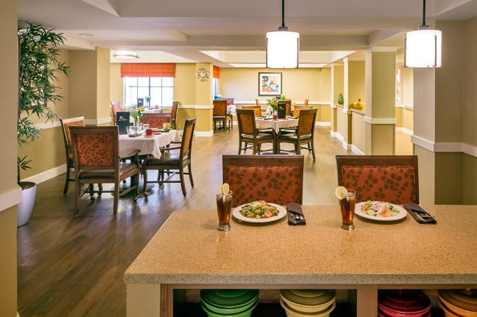 A spacious and well-lit dining area with multiple tables and chairs, creating a welcoming atmosphere.