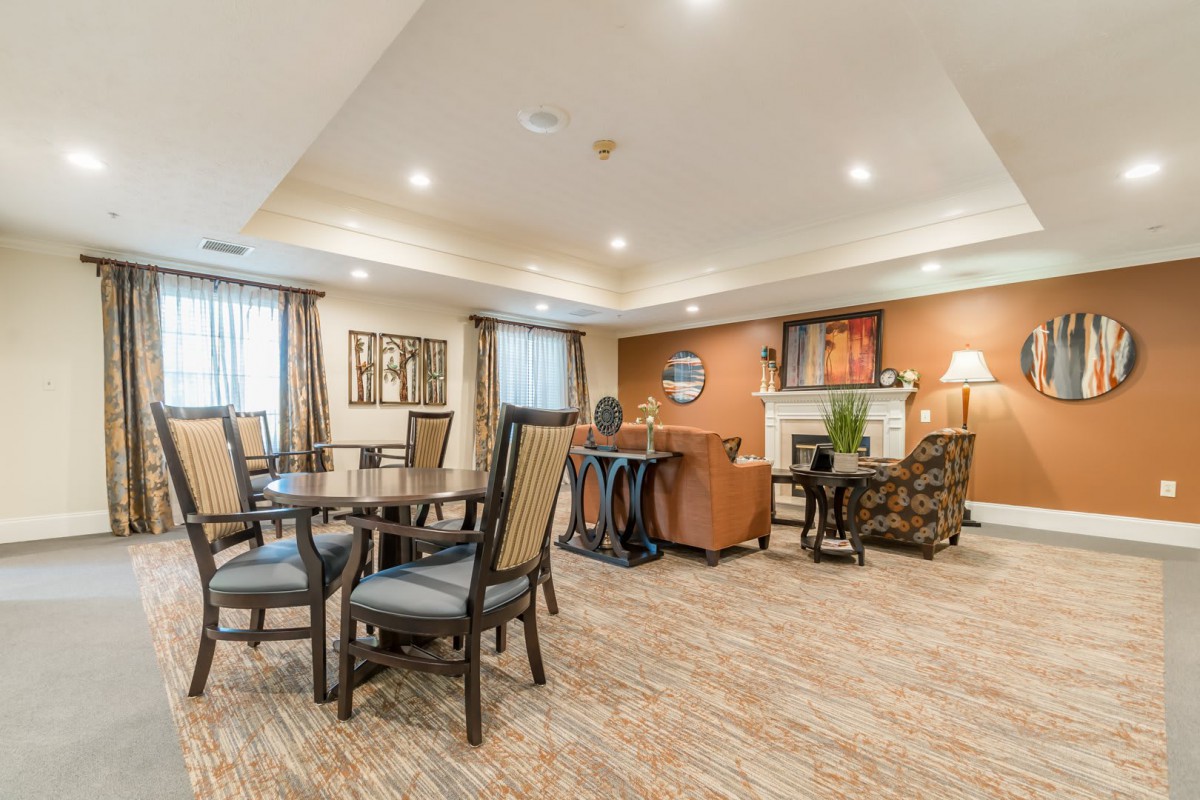 A cozy and well-lit seating area featuring tables, chairs, and comfortable furniture.