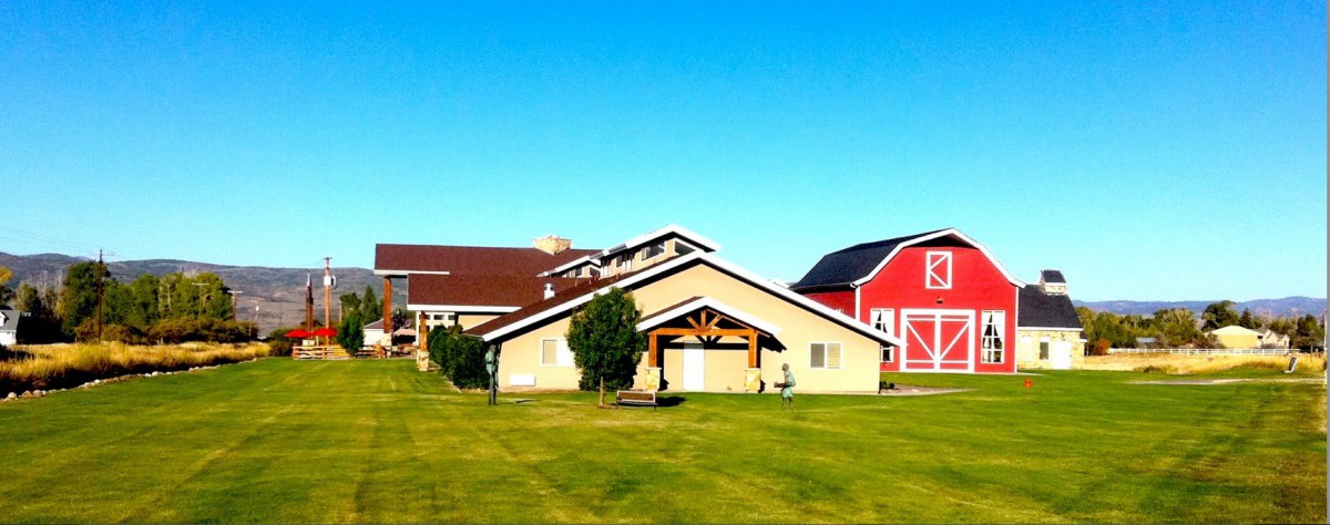 A picturesque rural scene featuring a barn and farm buildings under a clear blue sky.