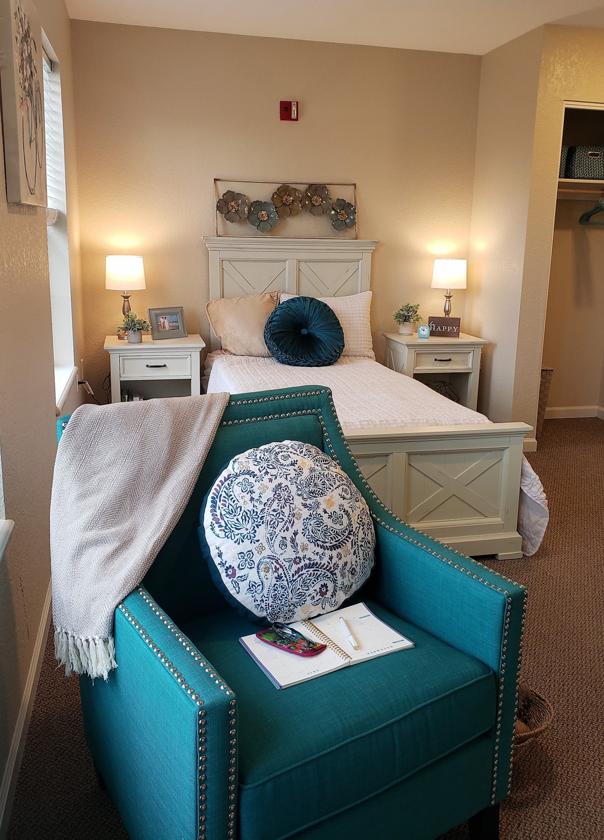 A cozy bedroom with elegant decor, featuring a comfortable chair and ambient lighting.
