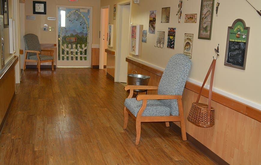 A quiet hallway featuring a wooden chair and various wall decorations.