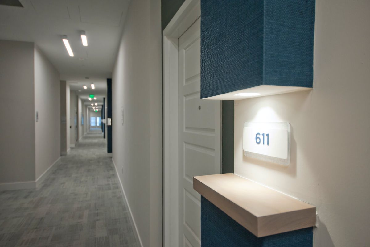 A modern hotel hallway with contemporary lighting and room numbered 611.