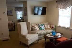 Cozy living room with a sofa, armchair, and wall-mounted TV.
