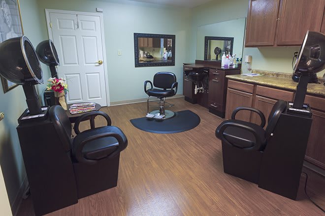 A cozy barbershop interior with a central hair cutting chair and mirrors.