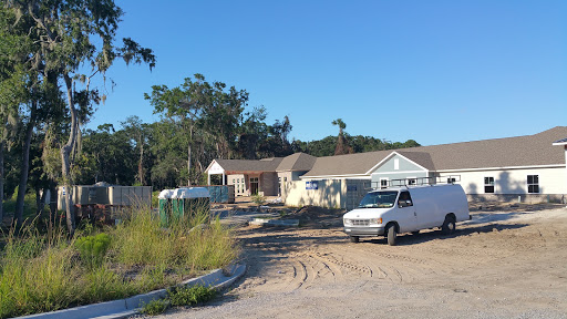 A construction site showing a house under development with vehicles parked nearby.