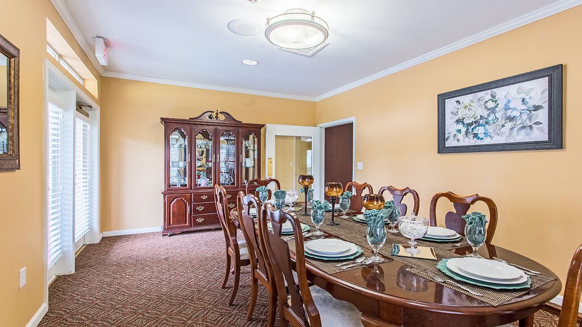 A beautifully set dining room with elegant furniture and a chandelier.