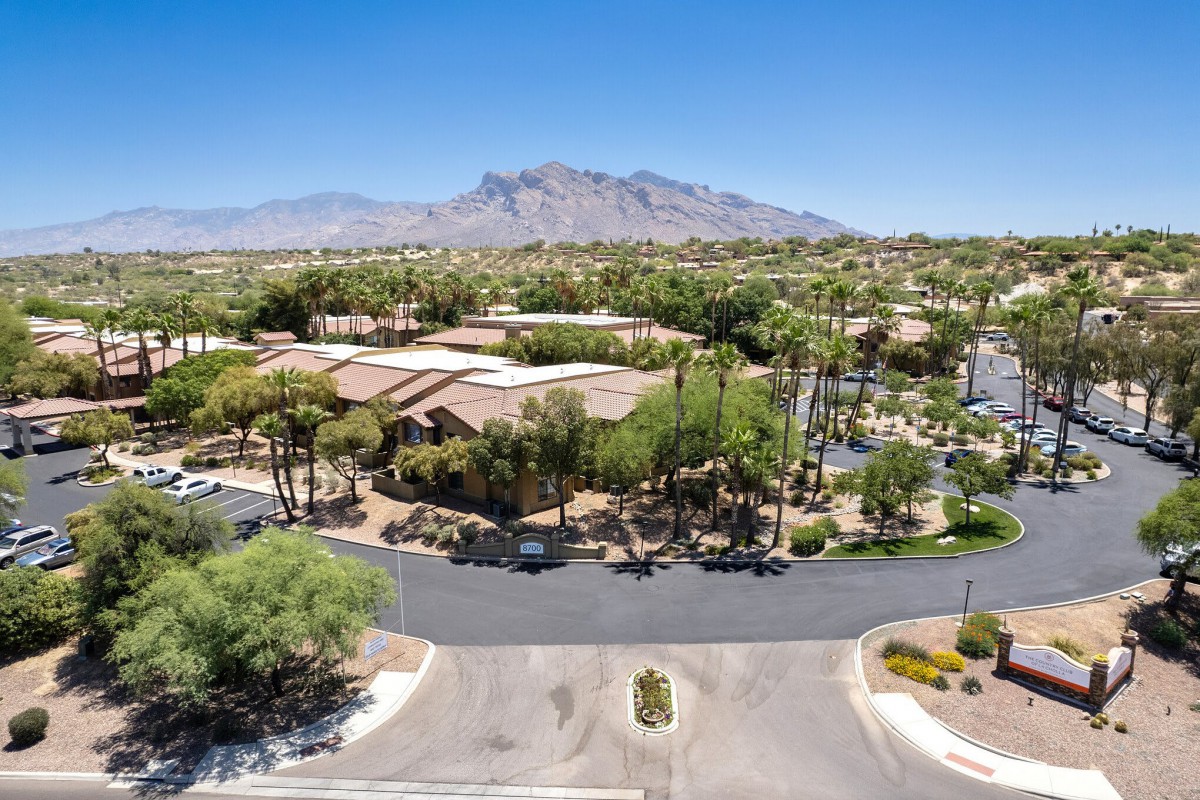Aerial view of a residential area with mountains in the background and a clear blue sky.