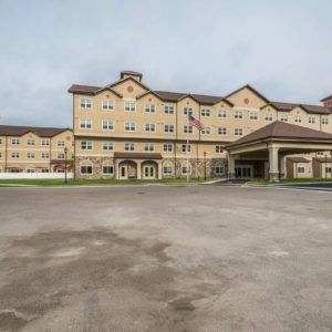 The exterior view of a large hotel with a spacious parking area.