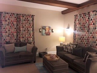 A cozy living room with patterned curtains and comfortable seating.
