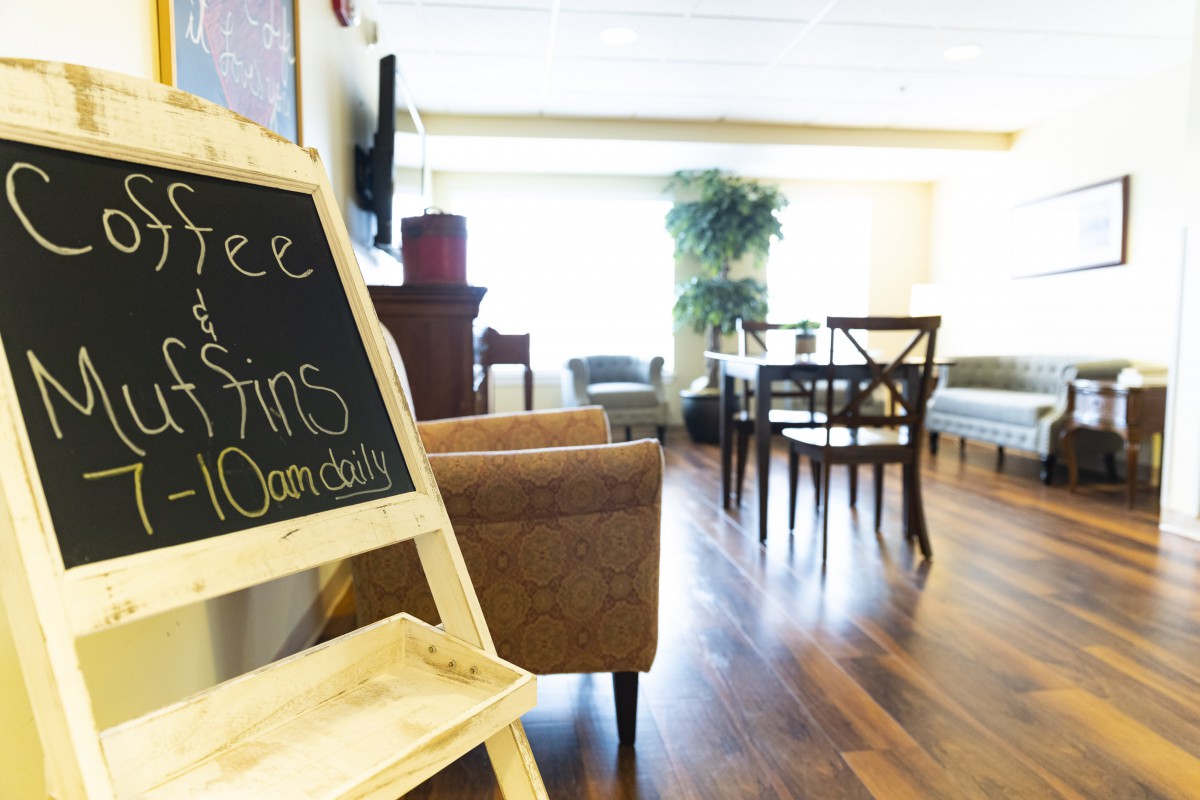 A cozy lounge area with comfortable seating and a chalkboard sign.