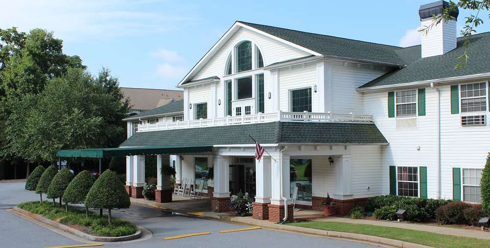 A large residential building with a front porch and multiple windows.