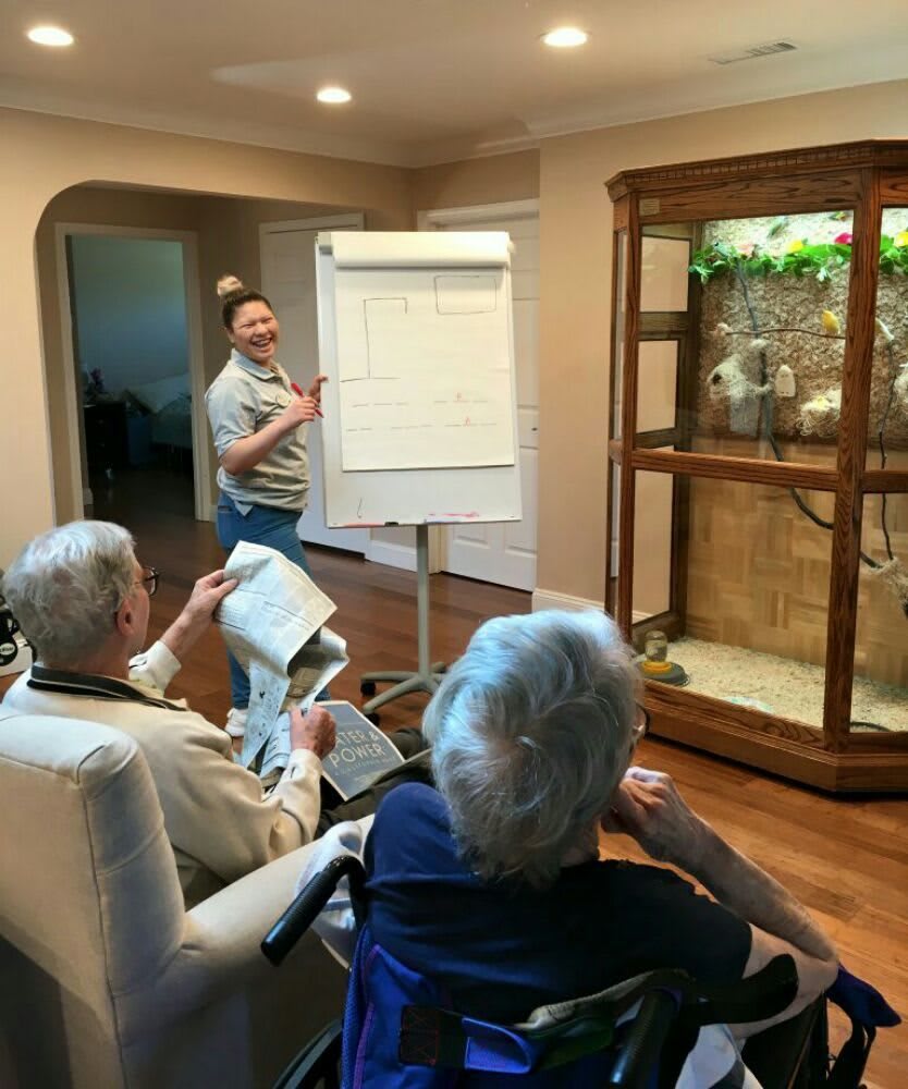 A group of people engaged in a presentation at home with a flip chart.