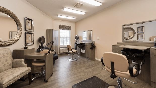 A modern beauty salon interior with styling stations and comfortable chairs.