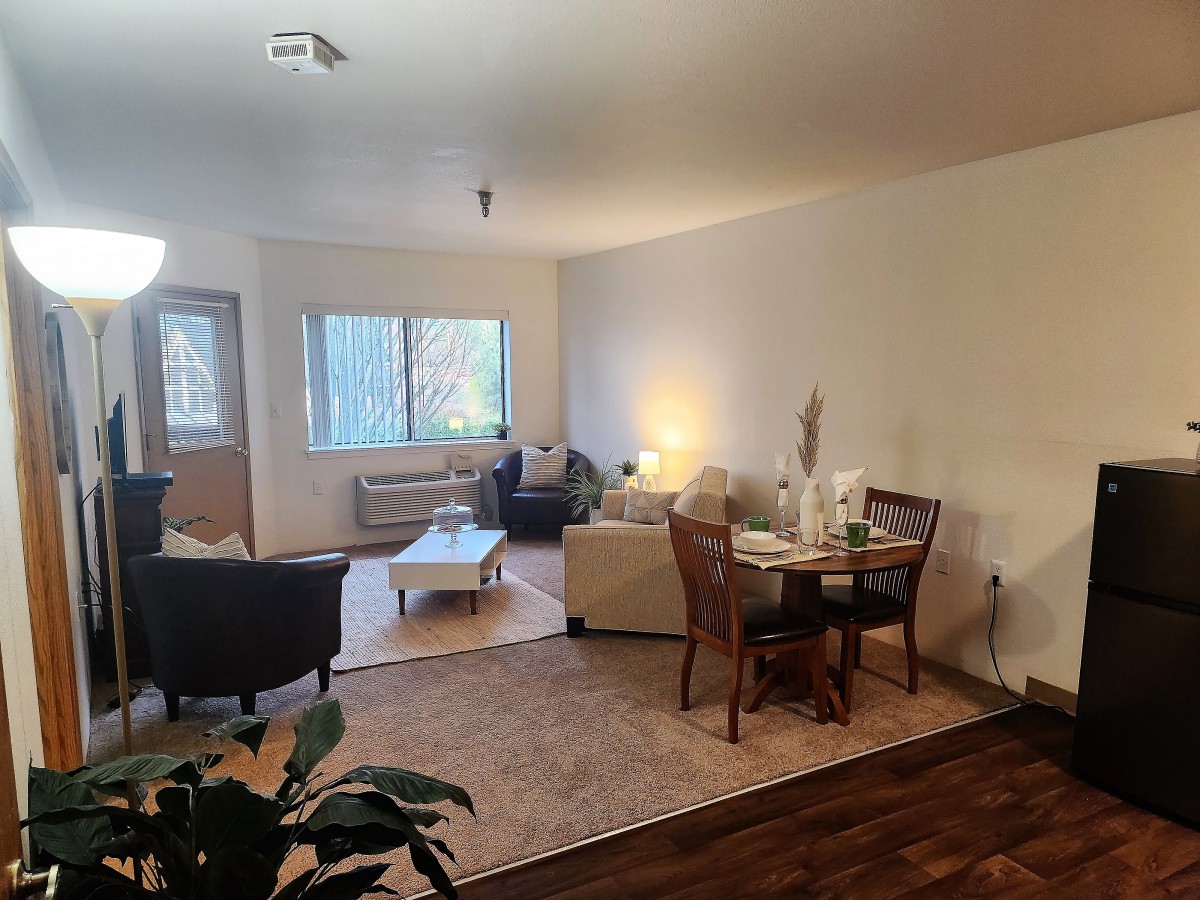 A cozy living room with a dining area, featuring comfortable furniture and soft lighting.