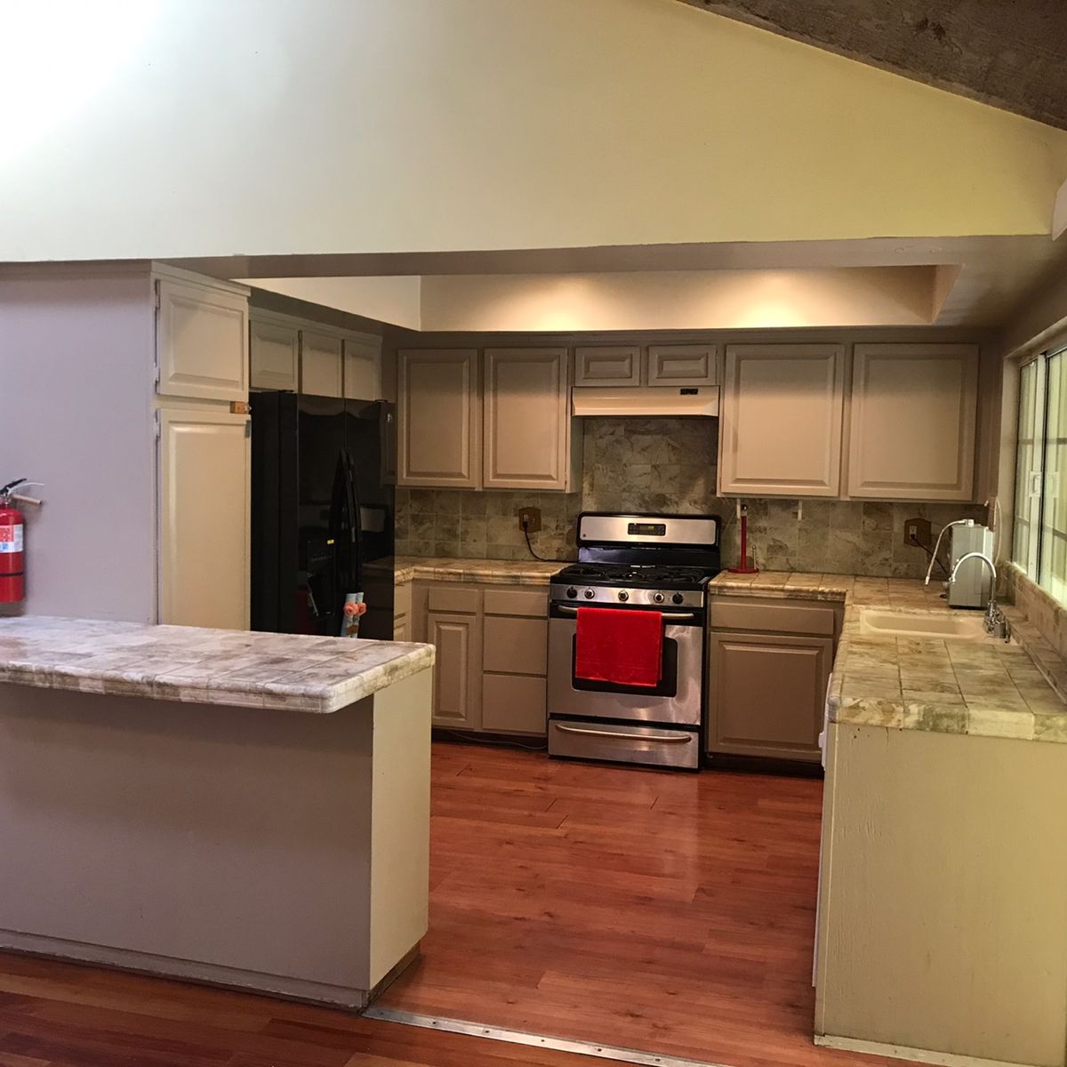 A modern kitchen with wooden floors and stone countertops.