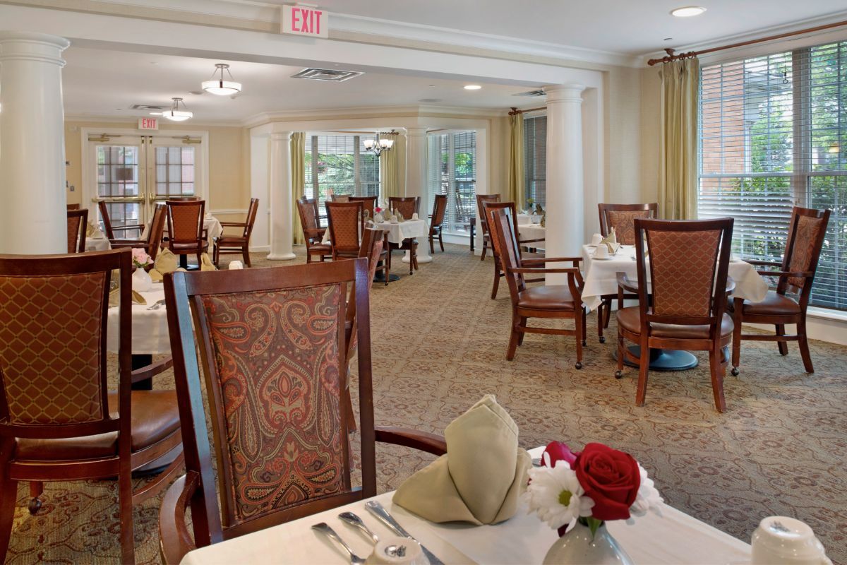 An elegant dining room with neatly arranged tables and chairs, featuring a warm and inviting decor.