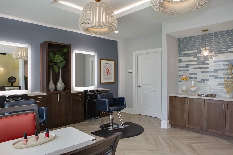 A modern salon with stylish decor, featuring a hair styling station and comfortable seating.