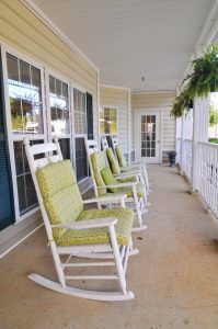 A cozy porch with rocking chairs and potted plants.