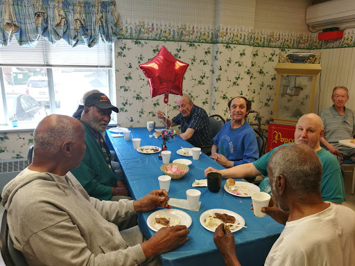 A group of elderly individuals enjoying a meal together in a communal setting.