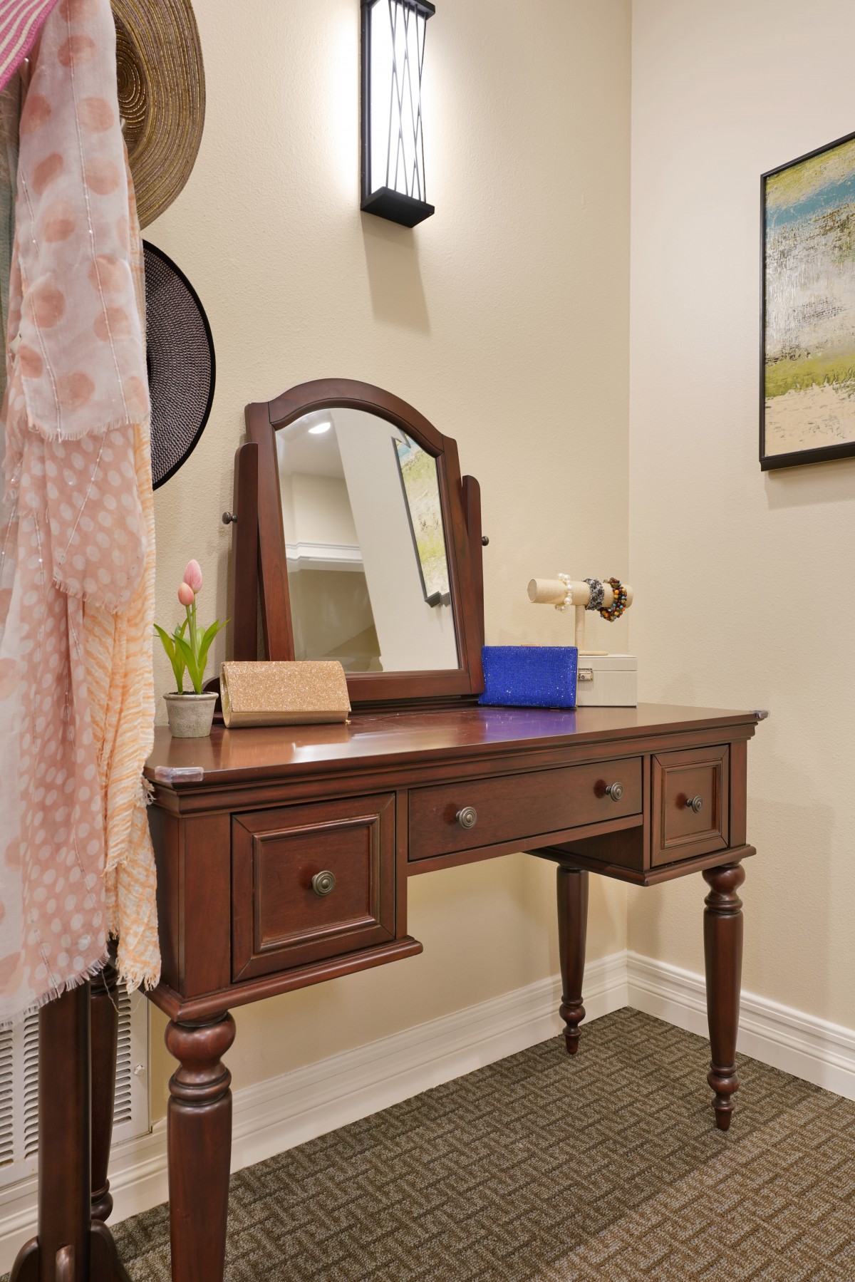 A wooden vanity with a mirror in a stylish bedroom setting.