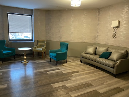 A spacious and modern living room featuring a comfortable sofa, stylish chairs, and elegant decor.