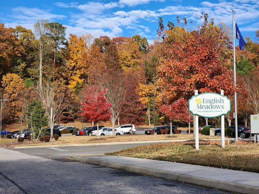 A picturesque autumn scene featuring vibrant fall foliage and a welcoming entrance sign.