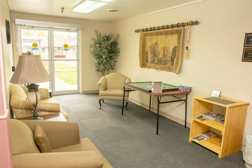 A cozy waiting area featuring comfortable chairs, a small table, and decorative elements.