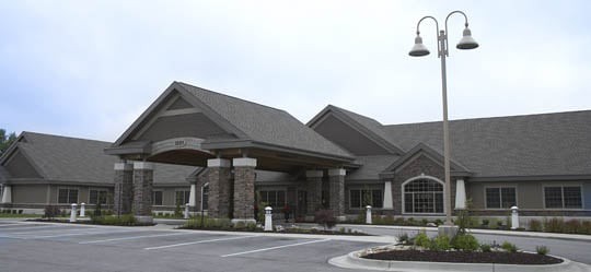 A commercial building with a stone facade and a parking area.