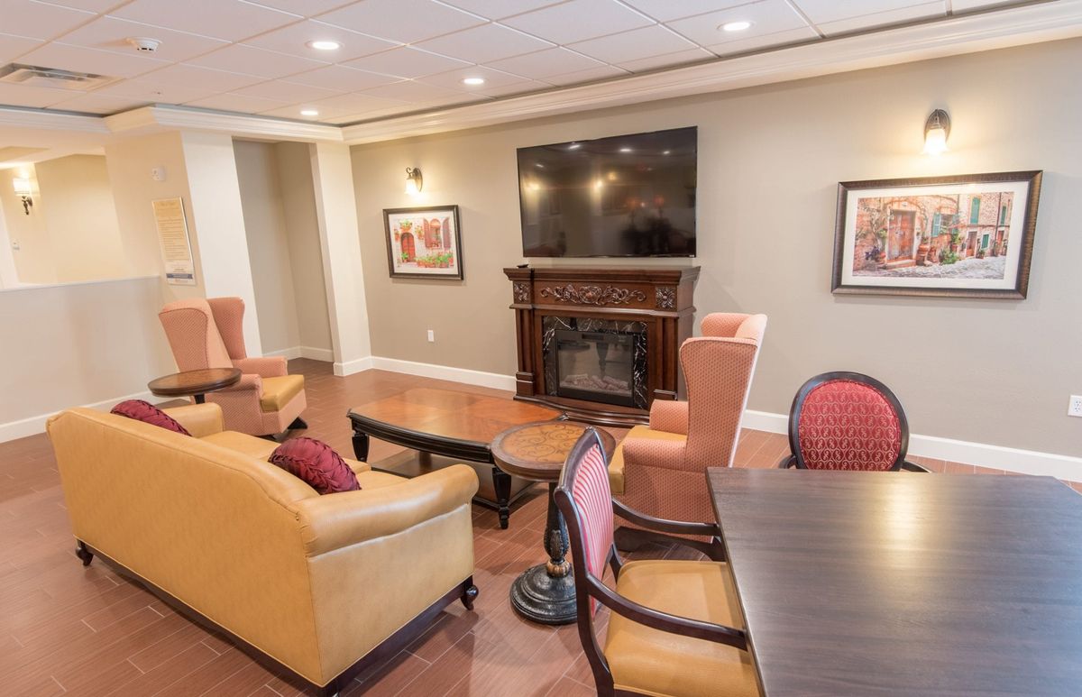A cozy living room with a fireplace and television, featuring comfortable seating.