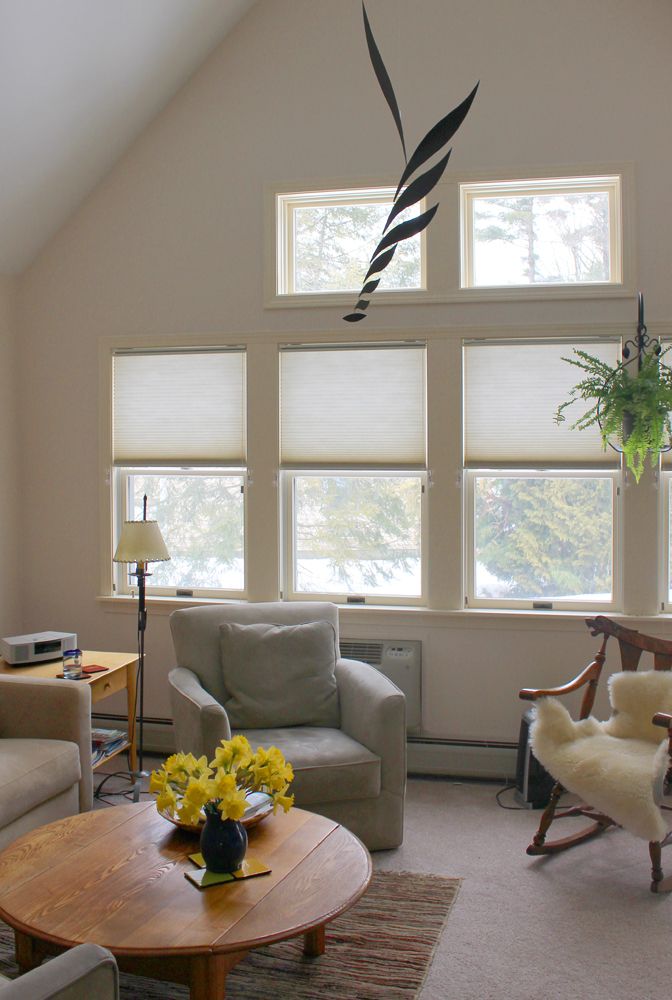A cozy living room with comfortable armchairs and ample natural light from large windows.