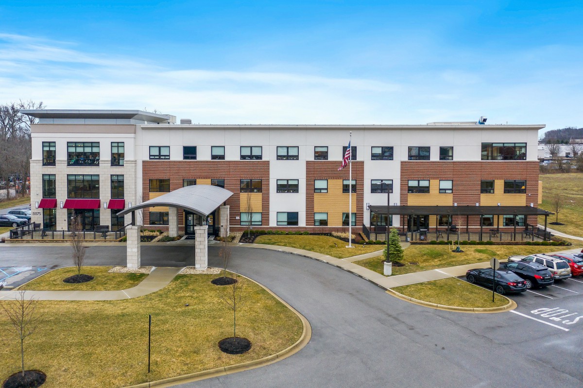 A modern hotel building with a landscaped entrance and driveway.