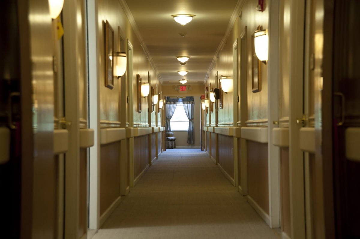 A well-lit hallway with symmetric design and decorative wall lamps.
