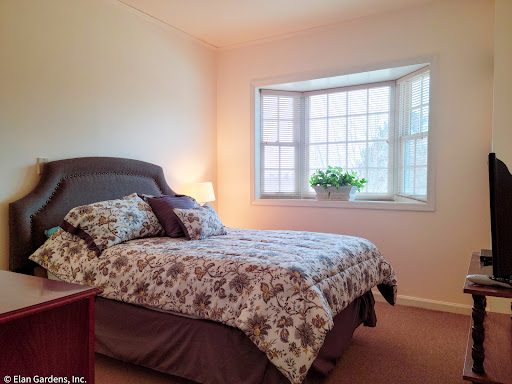 A cozy bedroom featuring a floral-patterned bedspread and a lovely bay window.