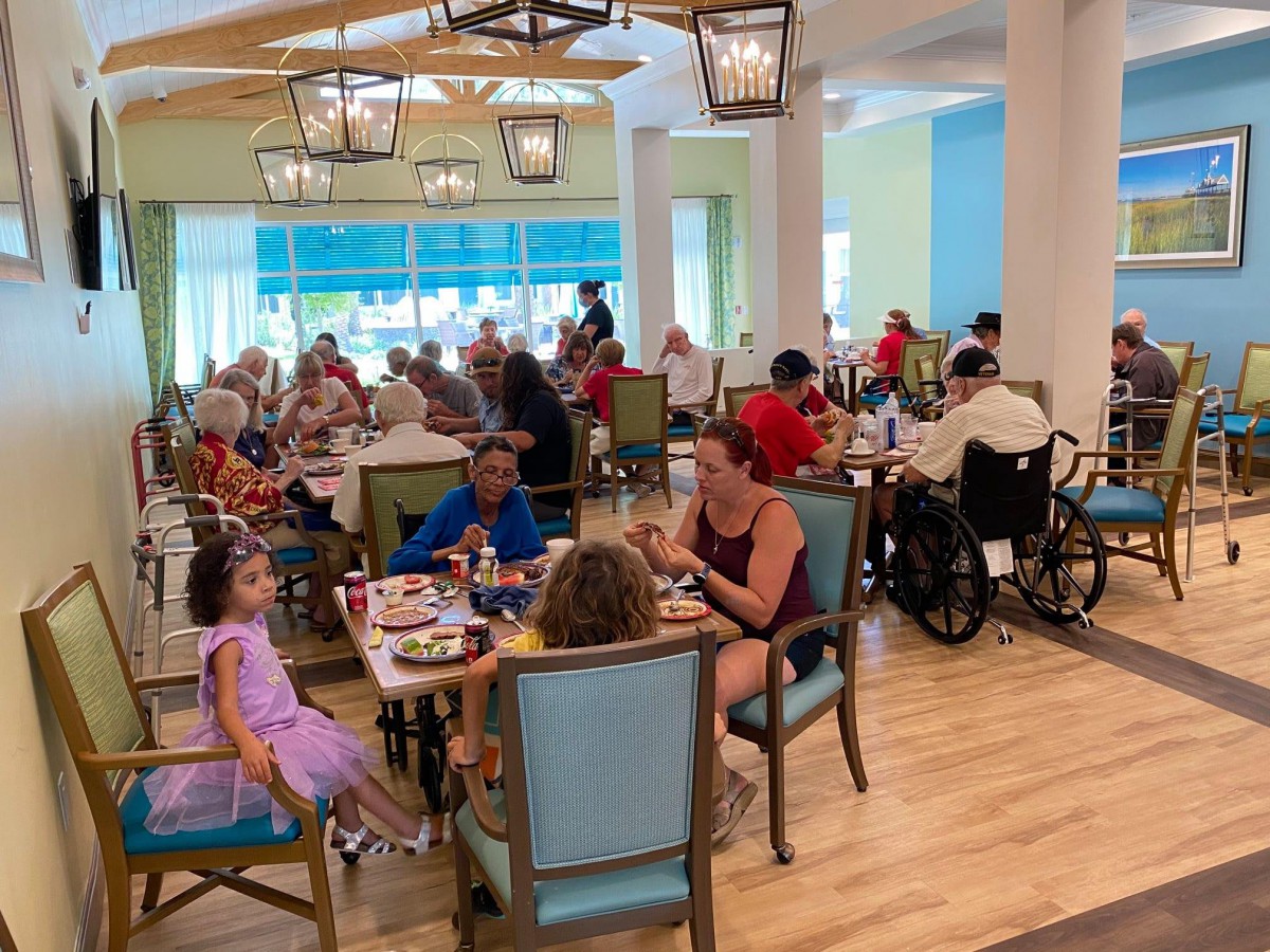 A lively restaurant scene with families and individuals dining together.