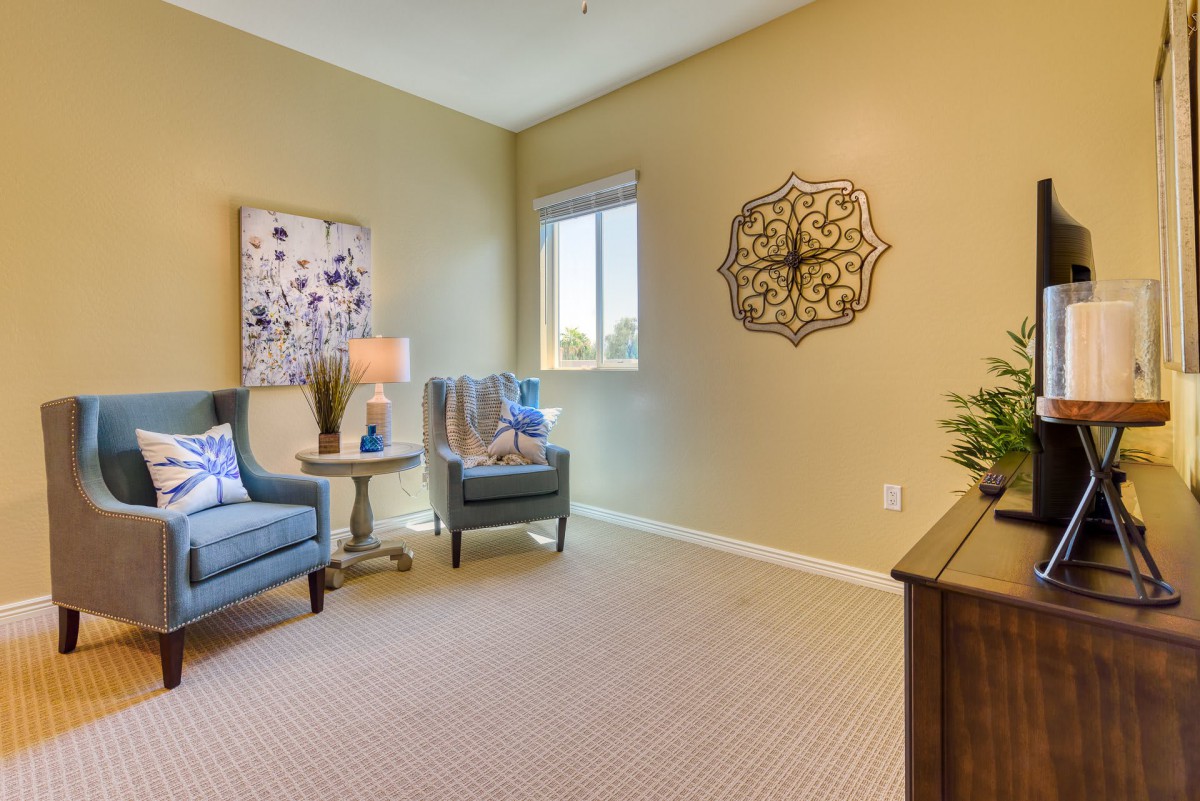 A cozy living room with comfortable chairs, a side table, and tasteful wall decor.