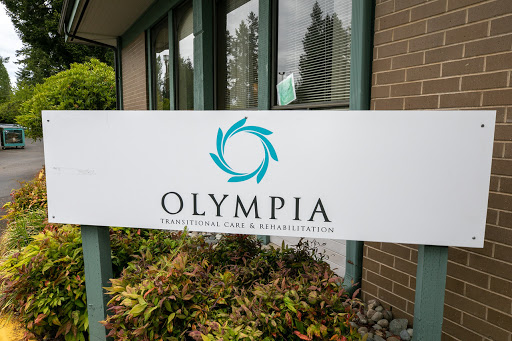 A sign displaying the name 'Olympia' outside a building.
