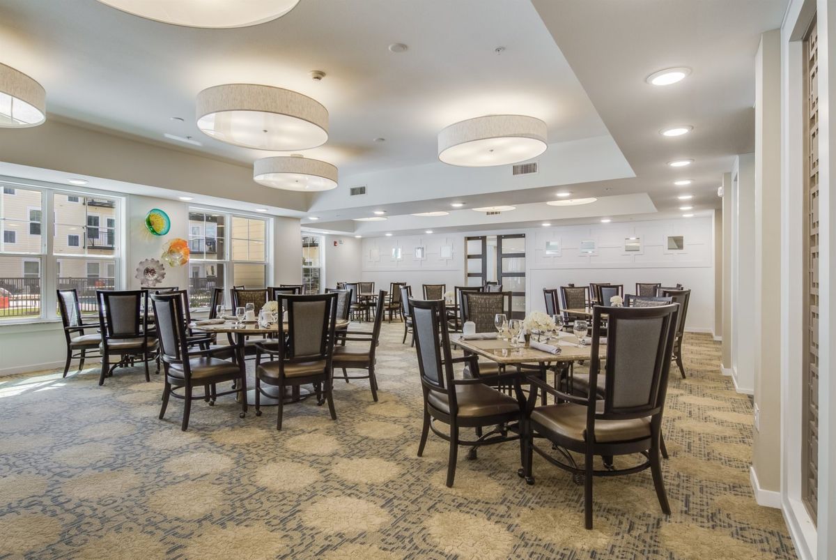 A well-lit, empty dining area with neatly arranged tables and chairs.
