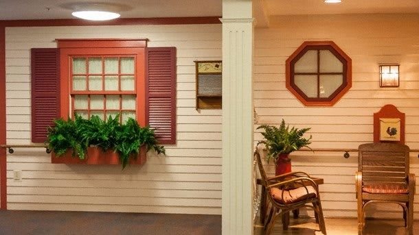 A cozy interior space with decorative shutters, plants, and a bench.