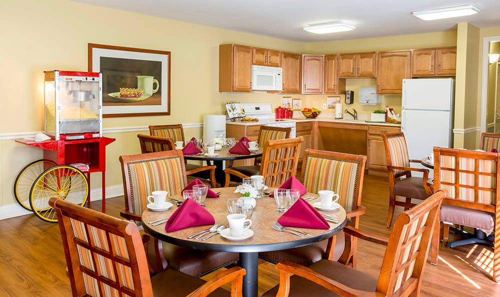 A cozy dining area with a set table and an adjacent kitchen.