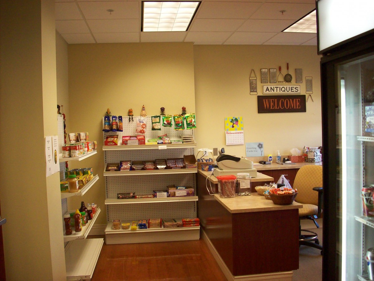 A reception area with a desk and shelves displaying various products.