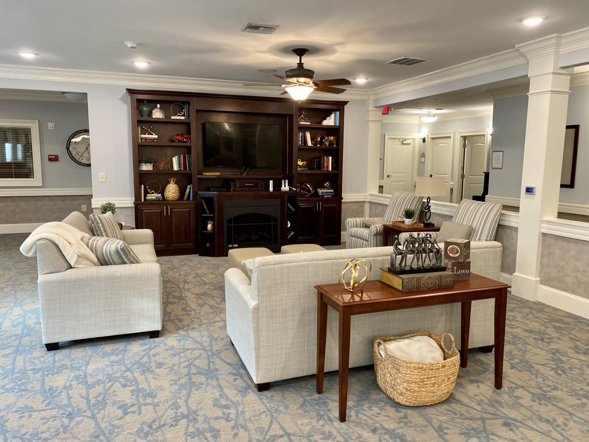 A cozy living room featuring comfortable seating, a central table, and built-in bookshelves surrounding a television.