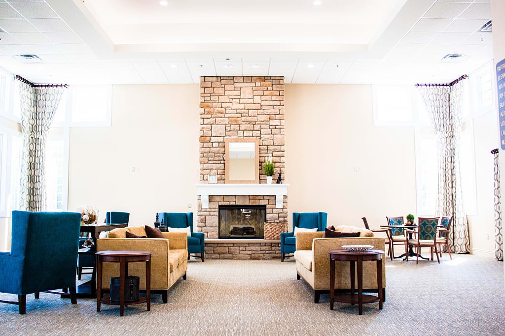 A cozy living room with a central fireplace surrounded by sofas and armchairs.