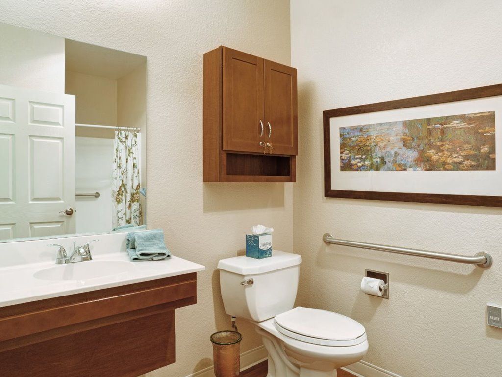 A neatly organized bathroom with a sink, toilet, and wall-mounted cabinet.