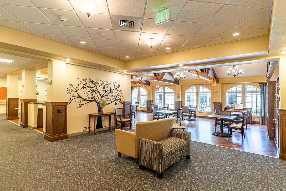 A cozy lounge area featuring comfortable seating, elegant chandeliers, and large windows.