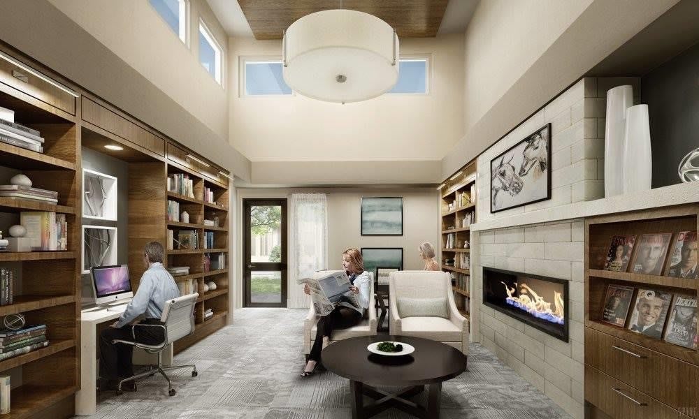 A modern living room with high ceilings, bookshelves, and a cozy fireplace.