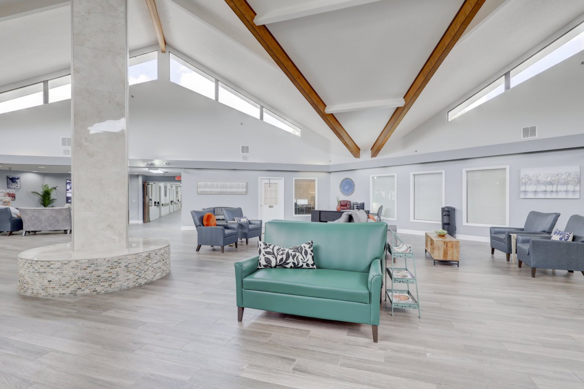 A modern and spacious living room with stylish furniture and wooden ceiling beams.